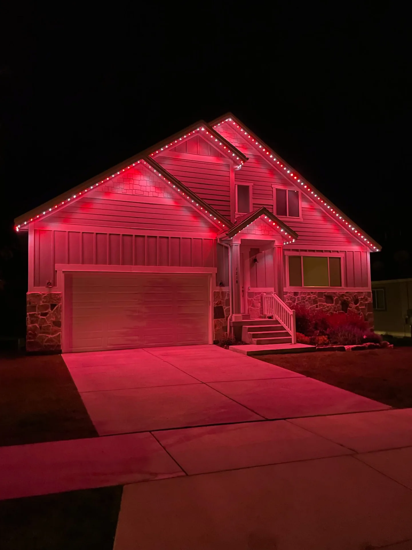 Two-story home lit in bold red for game day