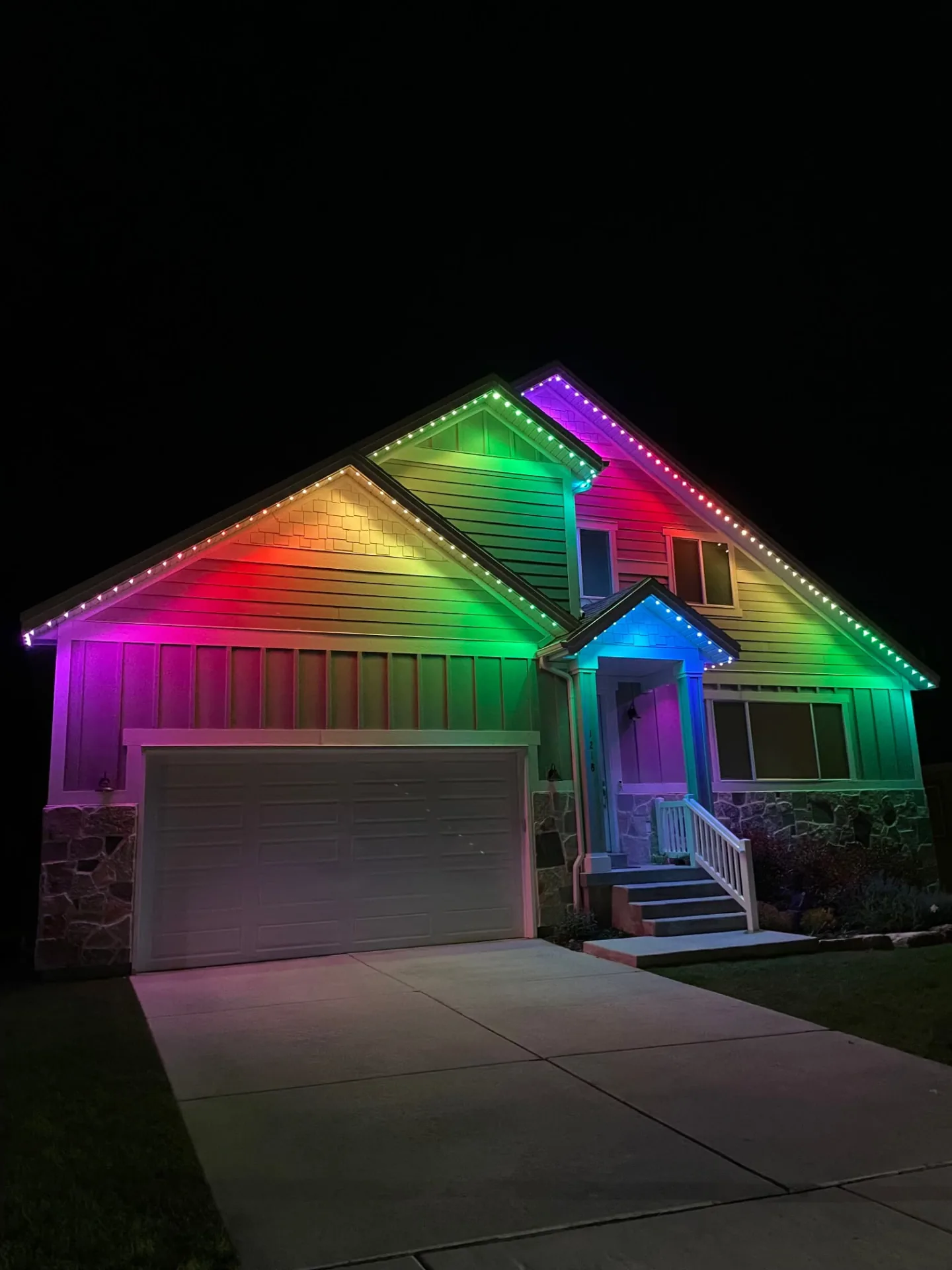 Home glowing in a rainbow of colors along the roofline